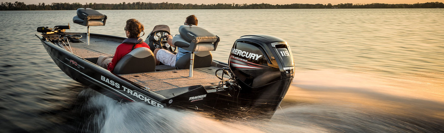 Two people on a 2019 Mercury Marine® Pro XS® dashing through a lake surrounded by trees. 